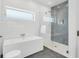 This contemporary bathroom features a soaking tub and glass-enclosed shower with stylish blue tiling at 905 Bay Point Dr, Madeira Beach, FL 33708