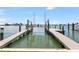Wide view of private dock with boat lift offering direct water access and scenic waterfront views at 905 Bay Point Dr, Madeira Beach, FL 33708