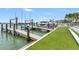 Dock with boat lift and adjacent manicured lawn, ideal for waterfront living and entertaining at 905 Bay Point Dr, Madeira Beach, FL 33708