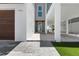 View of the front door and stilt construction of the house with light brick driveway at 905 Bay Point Dr, Madeira Beach, FL 33708