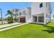 This waterfront home features a garage, artificial turf, and a covered outdoor area under the home at 905 Bay Point Dr, Madeira Beach, FL 33708