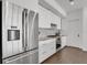 Modern kitchen featuring stainless steel appliances and sleek white cabinetry with gray backsplash at 905 Bay Point Dr, Madeira Beach, FL 33708