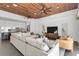 Open-concept living room with stylish furnishings, wood ceiling and a glimpse of the modern kitchen at 905 Bay Point Dr, Madeira Beach, FL 33708