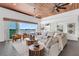 Open living room with cozy seating, wood ceilings, and sliding glass doors with water views at 905 Bay Point Dr, Madeira Beach, FL 33708