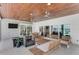 This covered outdoor space features a wood ceiling, recessed lighting, ceiling fans, and comfortable seating at 905 Bay Point Dr, Madeira Beach, FL 33708