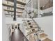 Modern staircase with floating wood steps, stainless steel railings, and stylish design elements at 905 Bay Point Dr, Madeira Beach, FL 33708