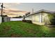 Backyard featuring the exterior of the sunroom, a storage shed, and a lush green lawn at 9120 108Th St, Seminole, FL 33772