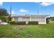 Exterior shot of a home with the sunroom, green lawn, and manicured shrubs at 9120 108Th St, Seminole, FL 33772
