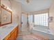 Bright bathroom with a glass-enclosed shower and a separate tub with glass block window at 920 Tuscanny St, Brandon, FL 33511