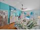 Bright bedroom overlooking pool area, with wood floors, ceiling fan, tropical bedding, and turquoise accent wall at 920 Tuscanny St, Brandon, FL 33511