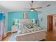 Well lit bedroom with wood floors, ceiling fan, tropical patterned bedding, and turquoise accent wall at 920 Tuscanny St, Brandon, FL 33511