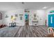 Open-concept living room with driftwood-style floors and coastal-themed decor leading to a bright blue door at 920 Tuscanny St, Brandon, FL 33511