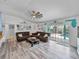 Open living room with driftwood-style flooring, a ceiling fan, and a view of the backyard pool at 920 Tuscanny St, Brandon, FL 33511
