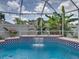 Relaxing pool with waterfall, red brick and blue tile border, and tropical foliage at 920 Tuscanny St, Brandon, FL 33511