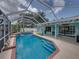 Enclosed pool with a tanning ledge, blue tile trim, and a view of the patio and tropical landscaping at 920 Tuscanny St, Brandon, FL 33511
