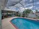 A screened-in pool area with brick patio and tropical landscaping at 920 Tuscanny St, Brandon, FL 33511