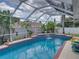Beautiful enclosed pool featuring blue tile accents, waterfall, and tropical landscaping for a relaxing outdoor experience at 920 Tuscanny St, Brandon, FL 33511
