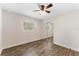 Neat bedroom with a mirrored closet, light walls, updated ceiling fan, and wood-look flooring at 9819 Allen Rd, Lithia, FL 33547