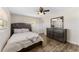 Comfortable bedroom with a queen bed, wood-look flooring, modern ceiling fan, and a dresser with mirror at 9819 Allen Rd, Lithia, FL 33547