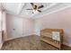 Light pink bedroom with wood-look flooring, a crib and a large window at 9819 Allen Rd, Lithia, FL 33547