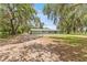 Single story home with large front yard, gravel driveway and mature trees with Spanish moss at 9819 Allen Rd, Lithia, FL 33547