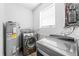 Laundry room featuring new machines and a water heater at 9819 Allen Rd, Lithia, FL 33547