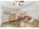 Cozy main bedroom with a wooden bed frame, a sitting area, a wooden dresser, and wood-look tile flooring at 9819 Allen Rd, Lithia, FL 33547