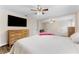 Spacious main bedroom featuring a queen size bed, dresser, and large television; ample space and natural light at 9819 Allen Rd, Lithia, FL 33547
