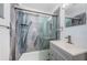Clean bathroom featuring modern shower with glass doors and stylish blue accent panel at 8184 49Th N Ave, St Petersburg, FL 33709
