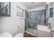 Bathroom with modern shower, glass doors, stylish blue accent panel, and gray vanity at 8184 49Th N Ave, St Petersburg, FL 33709