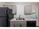 Well-lit kitchen boasts black appliances, speckled counters, and ample gray cabinet space at 8184 49Th N Ave, St Petersburg, FL 33709