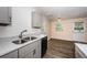 Open kitchen view with stainless sink, black dishwasher, and dining area in background at 8184 49Th N Ave, St Petersburg, FL 33709