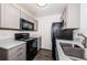 Kitchen with stainless steel appliances, dark wood floors, and gray cabinets at 8184 49Th N Ave, St Petersburg, FL 33709