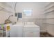 This laundry room features a washer, dryer, water heater, and storage shelves at 8184 49Th N Ave, St Petersburg, FL 33709