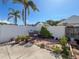Backyard seating area with lush plants, beautiful sunny sky, and tropical palms at 7516 S Mascotte St, Tampa, FL 33616