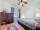 Serene bedroom featuring a ceiling fan, natural light, and ample storage with built-in drawers and classic wooden furniture at 7516 S Mascotte St, Tampa, FL 33616