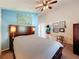 Bright bedroom with blue accent wall, ceiling fan, and a cozy atmosphere enhanced by unique decor and furnishings at 7516 S Mascotte St, Tampa, FL 33616