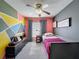 Cozy bedroom featuring a ceiling fan, colorful walls, and a stylish entertainment center at 7516 S Mascotte St, Tampa, FL 33616