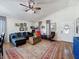 Comfortable living room with a ceiling fan, hardwood floors, a dark blue couch and large area rug at 7516 S Mascotte St, Tampa, FL 33616