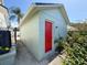 Light-blue outbuilding with a contrasting red door, adding charm to the property at 7516 S Mascotte St, Tampa, FL 33616