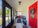 Covered porch with a red door and screened area featuring a tile floor and ceiling fan at 7516 S Mascotte St, Tampa, FL 33616