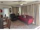 Cozy living room with a comfortable couch and chair, with curtains and a patterned rug at 10185 Santiago Ct, Seminole, FL 33776