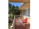 Outdoor patio with comfortable seating for relaxing on the porch, surrounded by tropical plants at 10185 Santiago Ct, Seminole, FL 33776