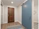 Bright entryway with a wood front door and a stylish blue sliding barn door at 11 Baymont St # 505, Clearwater Beach, FL 33767