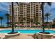 Beautiful waterfront pool with palm trees in a luxury beachfront condominium and lounge chairs at 11 Baymont St # 505, Clearwater Beach, FL 33767