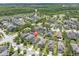 Aerial view of the property in a residential neighborhood surrounded by green spaces and a pond at 12382 Tibbetts St, Odessa, FL 33556