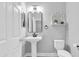 Modern powder room with sleek fixtures, a pedestal sink, and stylish decor at 12382 Tibbetts St, Odessa, FL 33556
