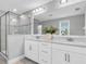 Bright bathroom with a double vanity, elegant countertops, and glass-enclosed shower at 12382 Tibbetts St, Odessa, FL 33556