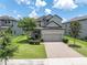 Charming two-story home with a brick driveway, well-manicured lawn, and mature trees creating curb appeal at 12382 Tibbetts St, Odessa, FL 33556