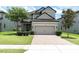 Charming two-story home with a brick driveway and attached two-car garage at 12382 Tibbetts St, Odessa, FL 33556